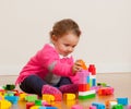 Toddler baby girl playing with rubber building blocks. Royalty Free Stock Photo