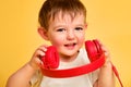 Toddler baby listens to music in red headphones on a studio yellow ba Royalty Free Stock Photo