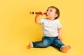 Toddler baby plays the flute, a child with a wind musical instrument on Royalty Free Stock Photo