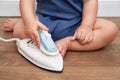 Toddler baby plays with a hot electrical iron. Child boy holding a dange