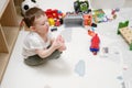 Toddler baby pulls her foot into her mouth while playing with toys in th Royalty Free Stock Photo