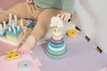 Toddler baby sitting on carpet playing with colorful wooden stacking toy Royalty Free Stock Photo