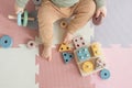 Toddler baby sitting on carpet playing with colorful wooden stacking toy Royalty Free Stock Photo