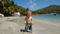 A toddler on a beach in the tropics