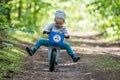 happy kid in forest with balance bike riding fast Royalty Free Stock Photo