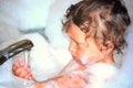 Toddler boy in bubble bath playing with faucet Royalty Free Stock Photo