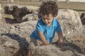 A toddler boy is carefully walking through some large rocks Royalty Free Stock Photo