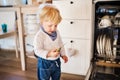 Toddler boy in dangerous situation at home. Child safety concept. Royalty Free Stock Photo