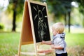 Toddler boy drawing standing by a blackboard Royalty Free Stock Photo