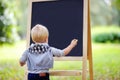 Toddler boy drawing standing by a blackboard Royalty Free Stock Photo