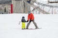 Toddler Boy Dressed Warmly & in Good Safety Gear Learns to Ski with his Dad Royalty Free Stock Photo