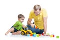 Toddler boy and his father repair toy tractor