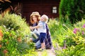 Toddler boy and his mother watering plants in the garden Royalty Free Stock Photo