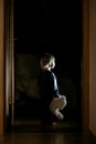 Toddler boy, hodling teddy bear, standing in hallway next to the door to bedroom, fairy tale picture Royalty Free Stock Photo