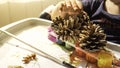 Toddler boy is painting yellow leaves and pine cones in fall with eco friendly paint. Sensorial activity at home