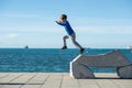 Toddler boy jumping from a stone sculpture by the sea Royalty Free Stock Photo