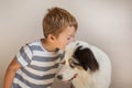 Toddler boy kissing australian shepherd indoor. Best friends consept. Royalty Free Stock Photo