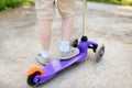 Toddler boy learning to ride scooter. Feet close up Royalty Free Stock Photo