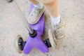 Toddler boy learning to ride scooter. Feet close up Royalty Free Stock Photo