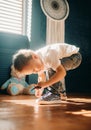 Toddler boy learns to tie the shoelaces on his sneakers Royalty Free Stock Photo