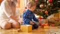 Cute toddler boy opens hristmas gift box on morning at living room Royalty Free Stock Photo