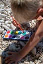 Toddler boy painting rocks with water colors Royalty Free Stock Photo