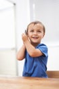 Toddler, boy and phonecall in house, happiness and communication with technology. Table, cheerful and conversation for Royalty Free Stock Photo