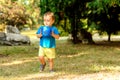 Toddler boy playing alone with blue soccer ball on grass lawn in sunny day. Visionary kid holding football ball and dreaming Royalty Free Stock Photo