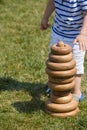 Toddler boy playing with big wooden toy pyramid on the grass outdoors on a sunny day