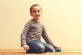 Toddler boy is playing in the house on the floor. A kid boy playing toy blocks inside his house. Happy little boy. Smiling child Royalty Free Stock Photo