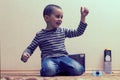 Toddler boy is playing in the house on the floor. A kid boy playing toy blocks inside his house. Happy little boy. Smiling child Royalty Free Stock Photo