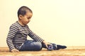 Toddler boy is playing in the house on the floor. A kid boy playing toy blocks inside his house. Happy little boy. Smiling child Royalty Free Stock Photo