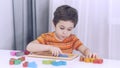 Toddler boy playing indoors with educational toy.