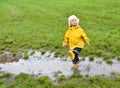 Toddler boy playing in a muddy puddle on a rainy day Royalty Free Stock Photo