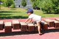 Toddler boy playing on playground - unstable wooden bridge