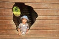 Toddler boy playing on playground - watching out from hole of boat