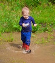 Toddler boy playing in water puddles