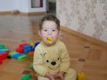 Toddler boy put a toy in his mouth. Child safety concept, dangerous child play Royalty Free Stock Photo