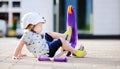 Toddler boy learning to ride scooter Royalty Free Stock Photo