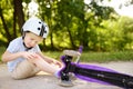 Toddler boy in safety helmet learning to ride scooter Royalty Free Stock Photo