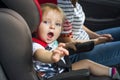 A toddler boy sitting in car seat. Little child in safety auto seat