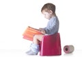 Toddler sitting on chamber pot reading story book Royalty Free Stock Photo
