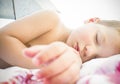 Toddler boy sleeping under beach umbrella shade