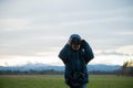 Toddler boy standing outside in a meadow observing nature with binoculars Royalty Free Stock Photo