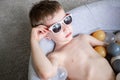 Toddler boy in sunglasses swimming in ball pool at home. Self isolation quarantine entertainment at home. Holiday Royalty Free Stock Photo