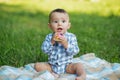 Toddler boy is teething. Baby gnaws toy while walking in park. Concept of childhood and nursery Royalty Free Stock Photo