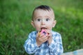 Toddler boy is teething. Baby gnaws toy while walking in park. Concept of childhood and nursery Royalty Free Stock Photo