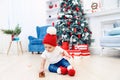 Toddler boy weared in festive clothes playing with christmas gift box. Concept of Christmas and New Year holidays. Royalty Free Stock Photo