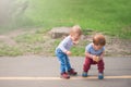 Toddler boys walk and play outside in spring