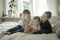 toddler brothers and sister sitting on bed together. Lifestyle family concept Royalty Free Stock Photo